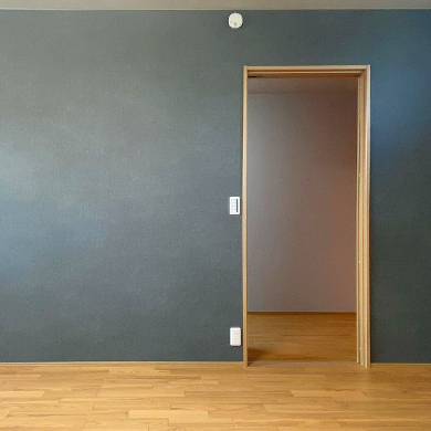 グレーのアクセントクロスと木目のコントラストが美しい寝室リフォーム